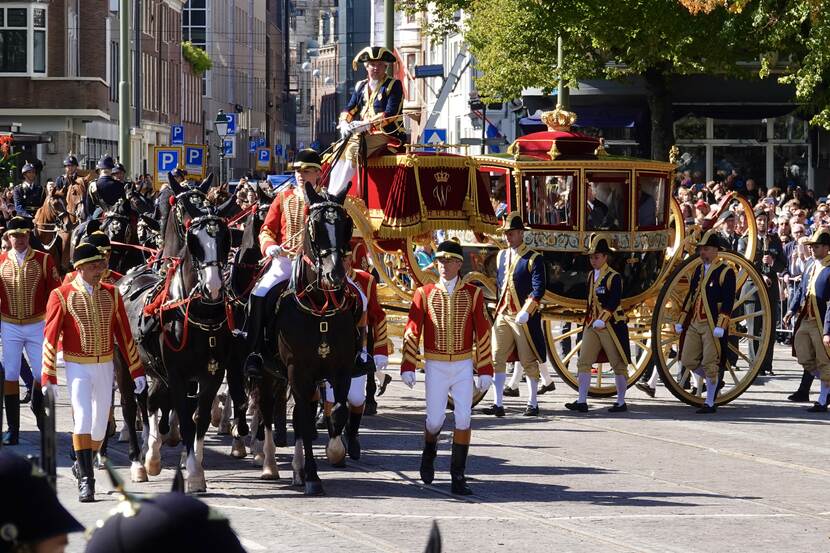 Koning Willem-Alexander, Koningin Máxima en de Prinses van Oranje rijden in de Glazen Koets naar de Koninklijke Schouwburg in Den Haag