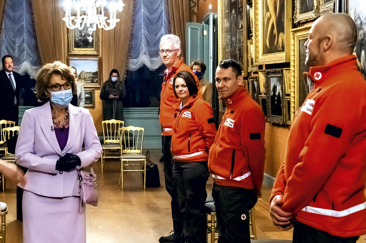 Prinses Margriet spreekt met mensen in Rode-Kruis-jassen.