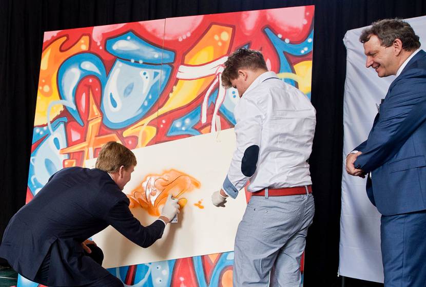 Leeuwarden, 31 mei 2013: Onder het toeziend oog van mr. Fred Winkel (R), president van het gerechtshof, spuit Koning Willem-Alexander zijn initialen op het kunstwerk van Bart Kok (M) bij de opening van het gerechtshof Arnhem-Leeuwarden tijdens een bijeenkomst in de Grote of Jacobijnerkerk in Leeuwarden