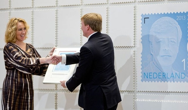 Koning Willem-Alexander neemt koningspostzegel in ontvangst.