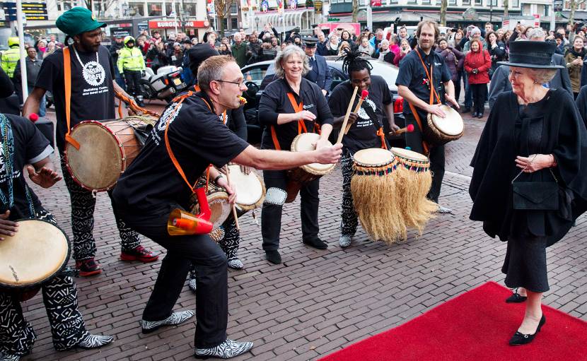 Prinses Beatrix komt aan bij de Stadsschouwburg, waar een perscussiegroep Zuid-Afrikaanse muziek speelt.