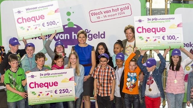 Koningin Máxima en presentator Klaas van Kruistum poseren met de winnaars van het project Gelduitdaging, tijdens de officiële opening van de nationale Week van het Geld in het Nederlands Instituut voor Beeld en Geluid