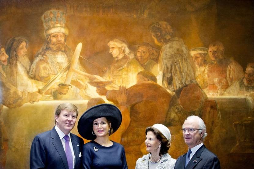 Koning Willem-Alexander en Koningin Máxima poseren met Koning Carl XVI Gustaf en Koningin Silvia in het Rijksmuseum voor het schilderij De Samenzwering van de Bataven onder Claudius Civilis van Rembrandt.