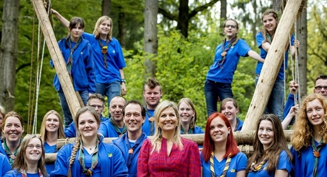 Koningin Máxima poseert met een groep meisjesscouts tijdens haar bezoek aan Scouting Lunteren. Koningin Máxima is beschermvrouwe van Scouting Nederland.