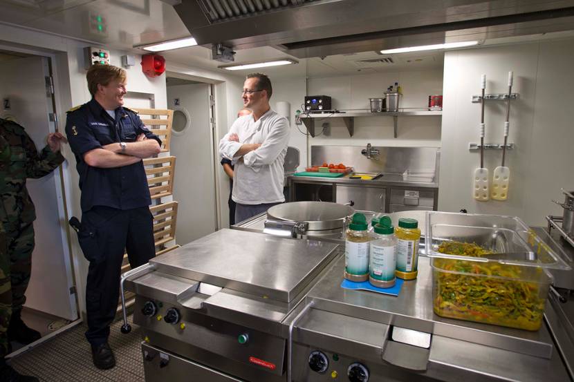 Koning Willem-Alexander spreekt de kok van een Nederlands marineschip dat deelneemt aan de marineoefening Northern Archer.