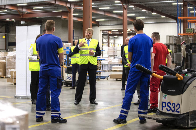 Koning Willem-Alexander in gesprek in een hal van het bedrijf Dachser