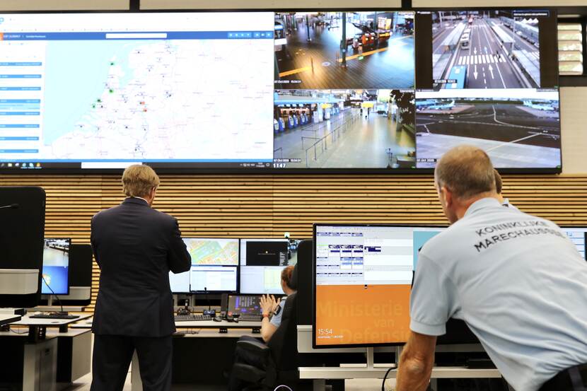 Koning spreekt met medewerkers van de Koninklijke Marechaussee.