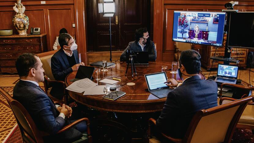Mannen spreken met Koningin Máxima via videoverbinding.