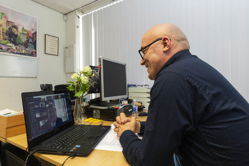 Meneer videobelt met Koning vanuit een kantoor.