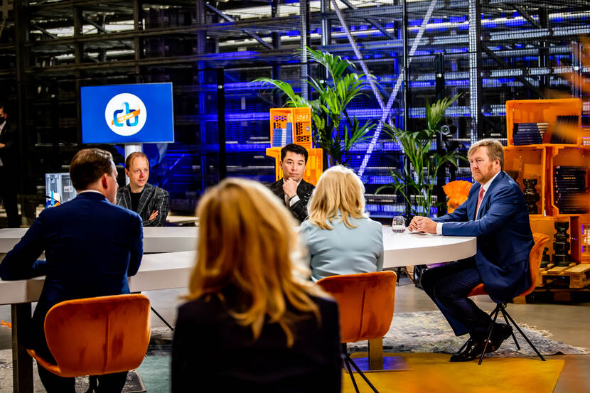 Koning Willem-Alexander aan tafel in gesprek met mensen uit het boekenvak.