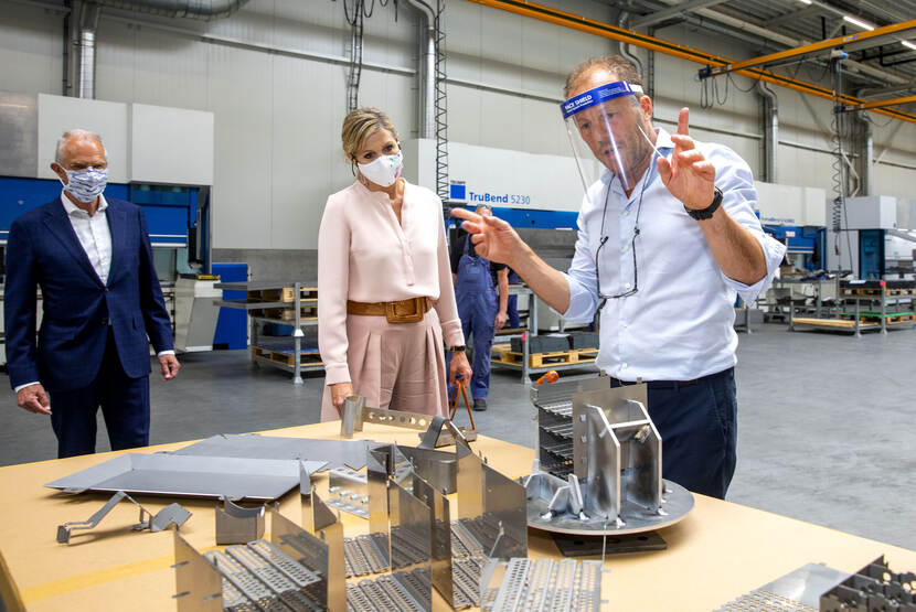 Koningin bekijkt metalen objecten.