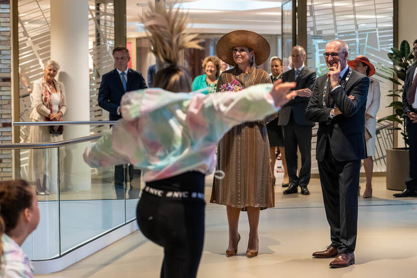 Koningin en burgemeester bekijken dansoptreden.