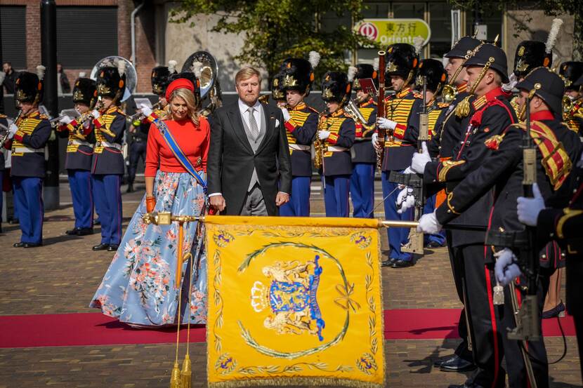 Koning Willem-Alexander en Koningin Máxima groeten het vaandel voor de ingang van de Grote Kerk.