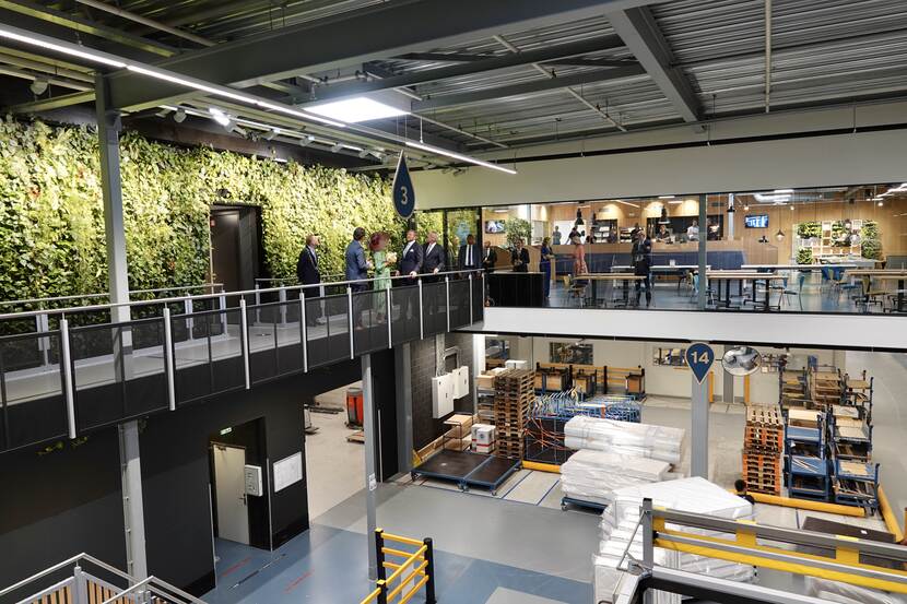 Blik in de fabriek van Koninklijke Auping in Deventer met links het Koninklijk Paar.