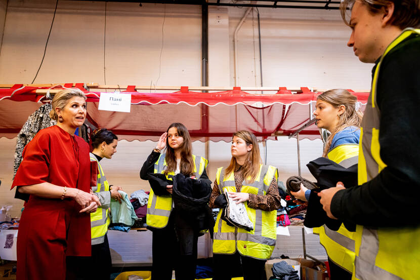Koningin Máxima in gesprek bij een groep mensen.