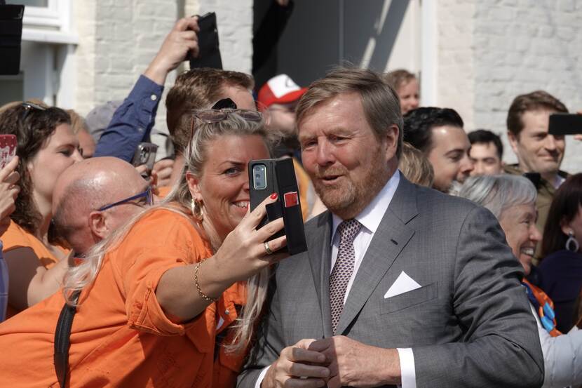 Koning Willem-Alexander maakt een selfie tijdens Koningsdag 2022.