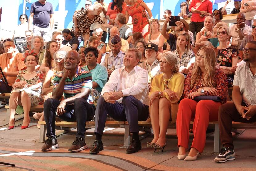 Koning Willem-Alexander, Koningin Máxima en de Prinses van Oranje bekijken in Otrobanda Curacao een muzikaal optreden