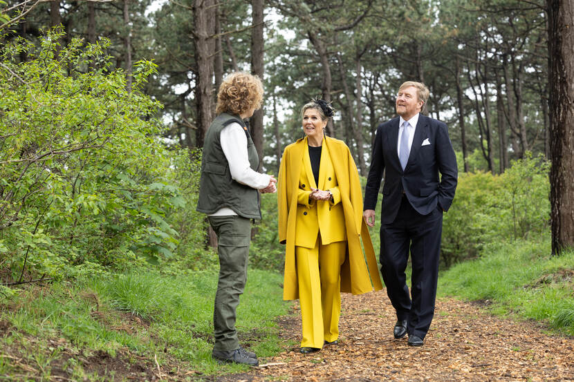 Koning Willem-Alexander en Koningin Máxima in gesprek in een bos