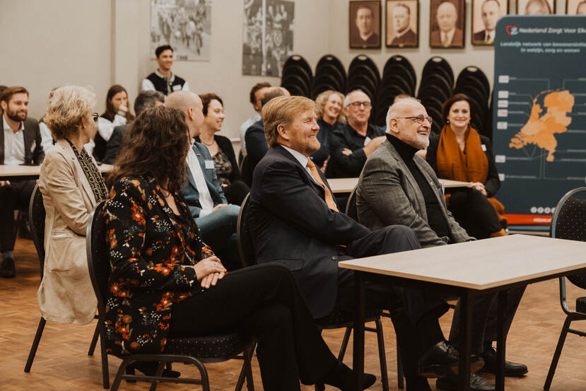 De Koning zit in de zaal bij het symposium 'Zorg op het Dorp', dat in het teken staat van de kenmerken en de knelpunten rond zorg en welzijn op het platteland, van bewonersinitiatieven en van de kracht van kleine gemeenschappen.