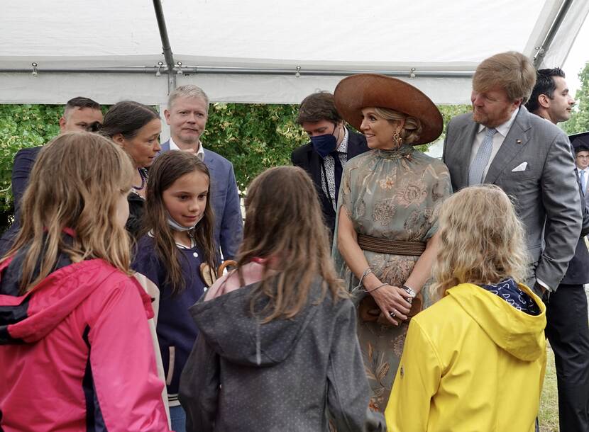 Koning Willem-Alexander en Koningin Maxima spreken met kinderen.